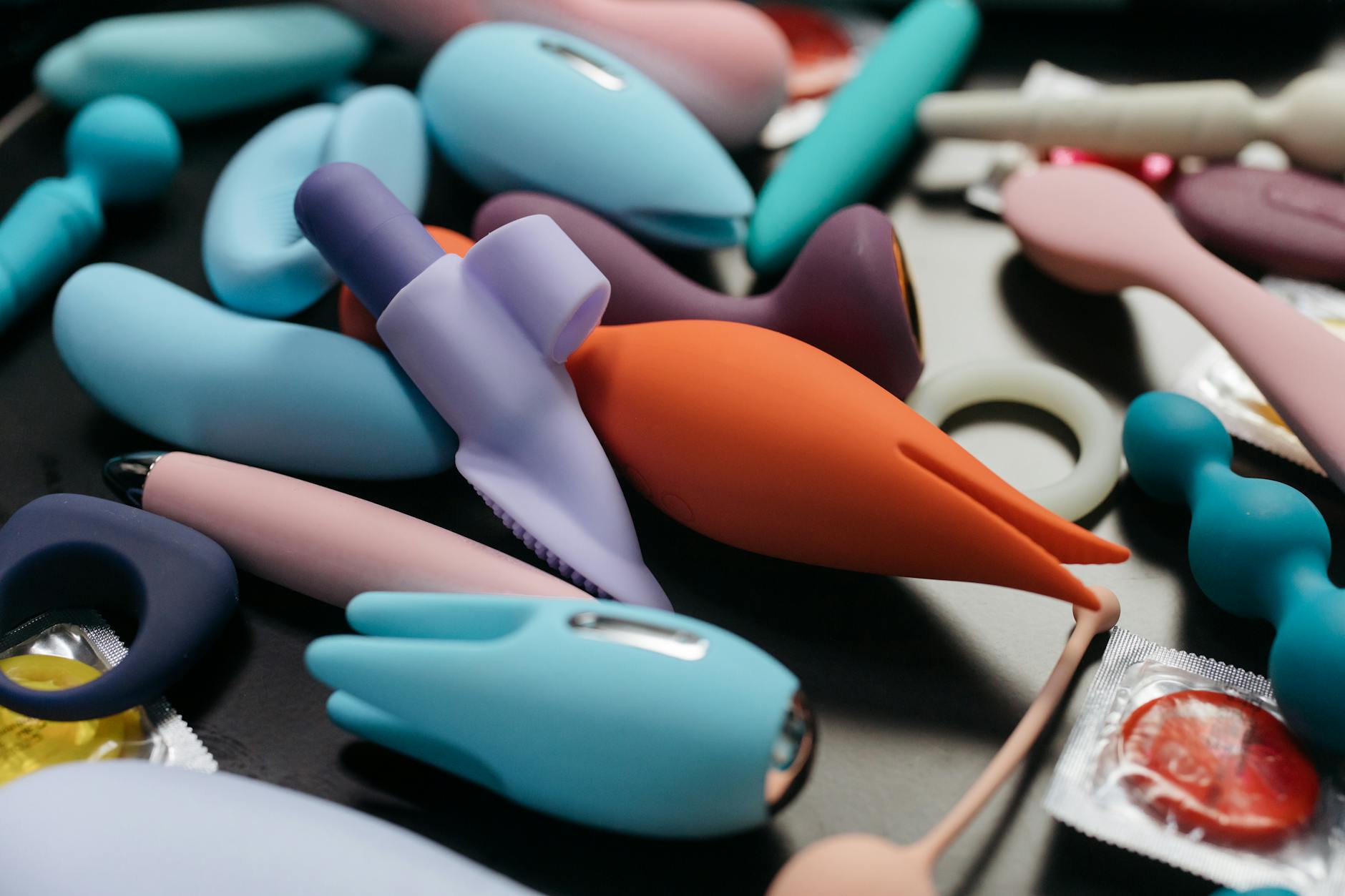 Hand holding an orange vibrator against a purple backdrop, representing intentional reconnection with pleasure