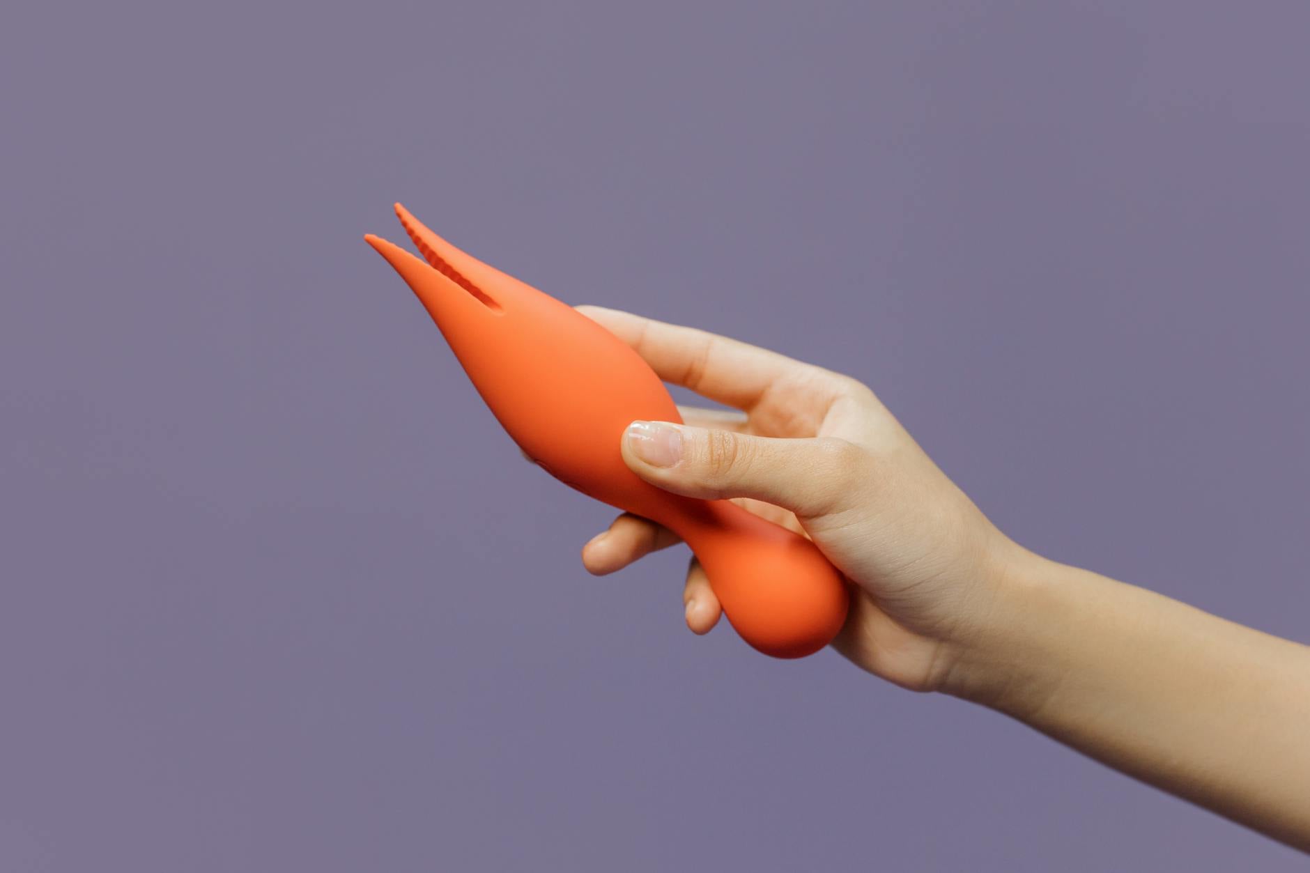 Hands holding a sleek blue clitoral vibrator, representing intimate partnership and shared pleasure