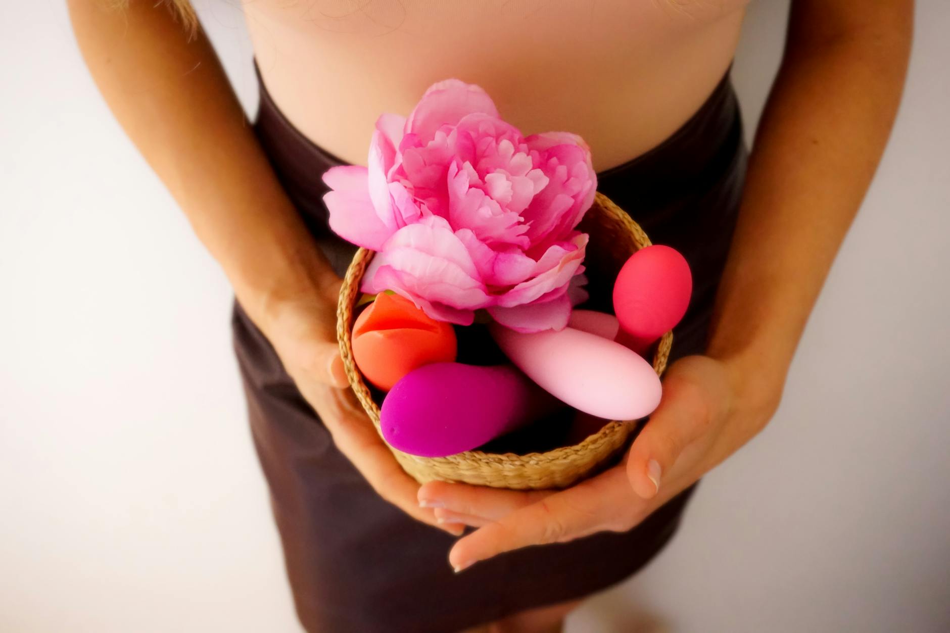 Colorful sex toys arranged on a bright yellow surface, showcasing modern pleasure products